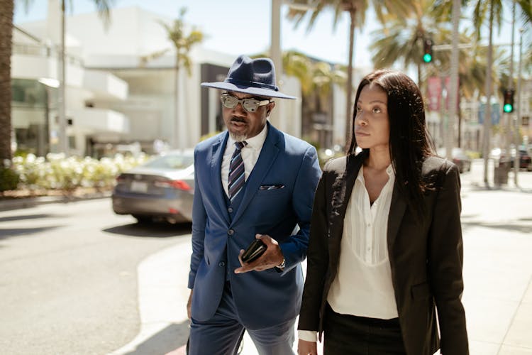 A Stylish Man And Woman Walking In The Street