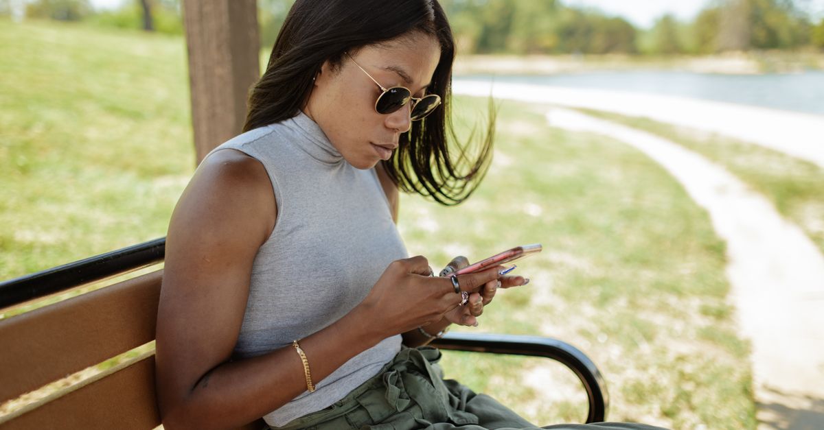 person sitting on a park bench looking at nature, no phone in hand