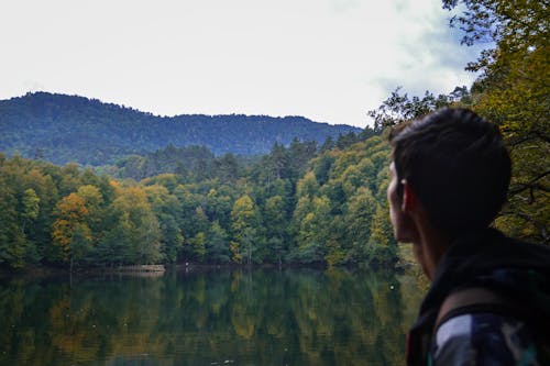 Man Standing Beside a Lake