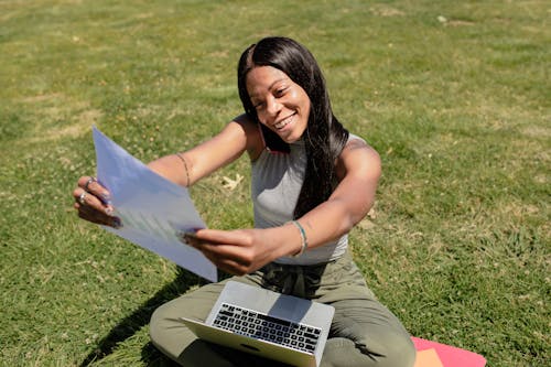 Woman Holding a Paper and Smiling