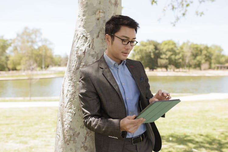 Man Wearing Corporate Attire Using His Ipad