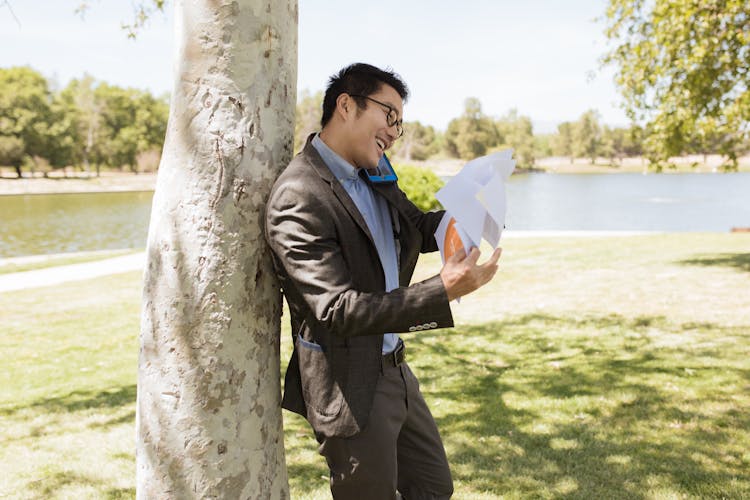 Man Talking On The Phone And Checking Documents