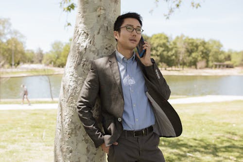 A Man Talking on a Smartphone at a Park