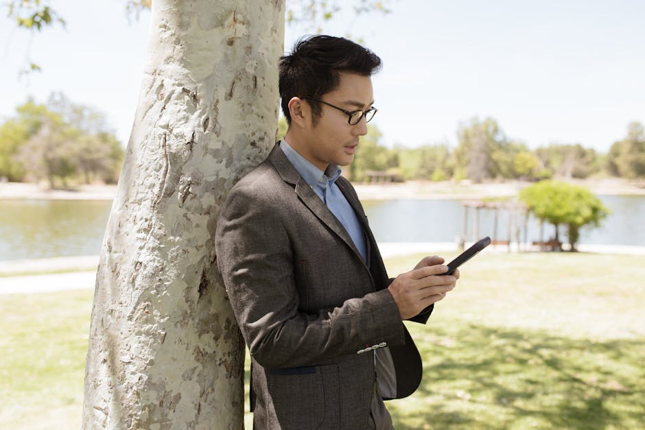Man in Gray Suit Jacket Holding Black Smartphone