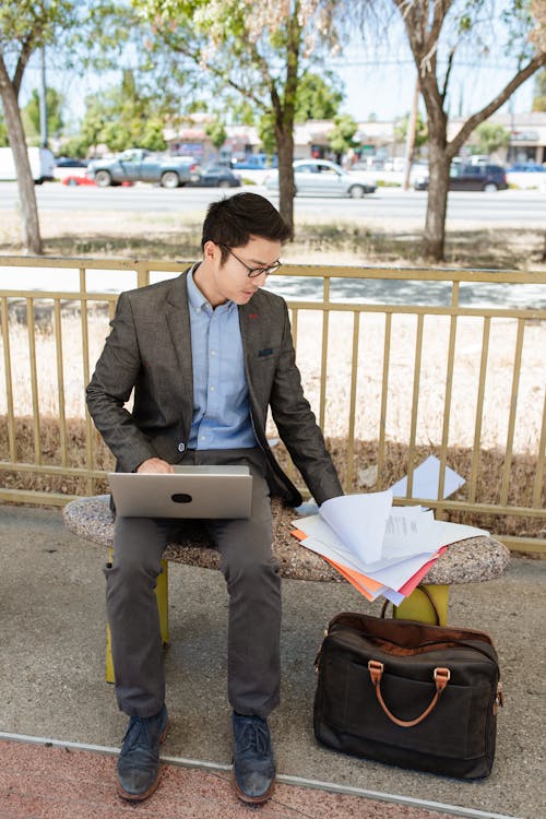 Man Sitting on Bench While Working