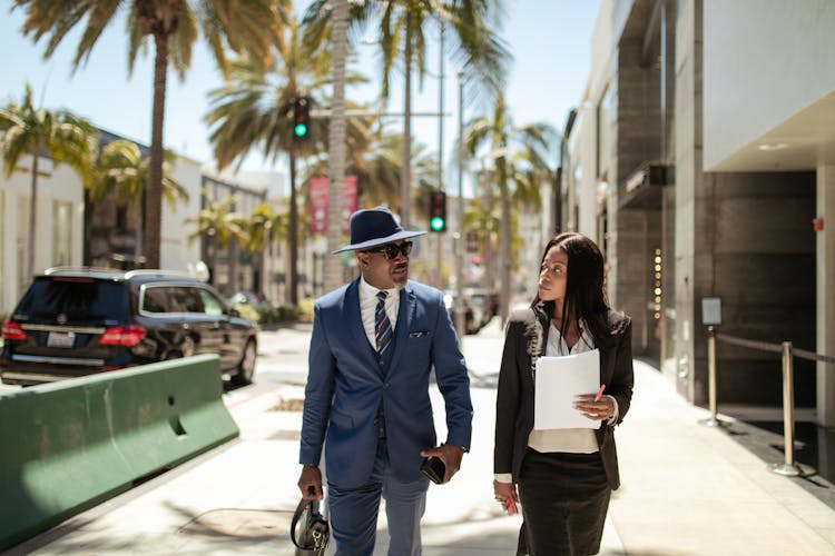 Man And Woman Walking On The Street While Talking