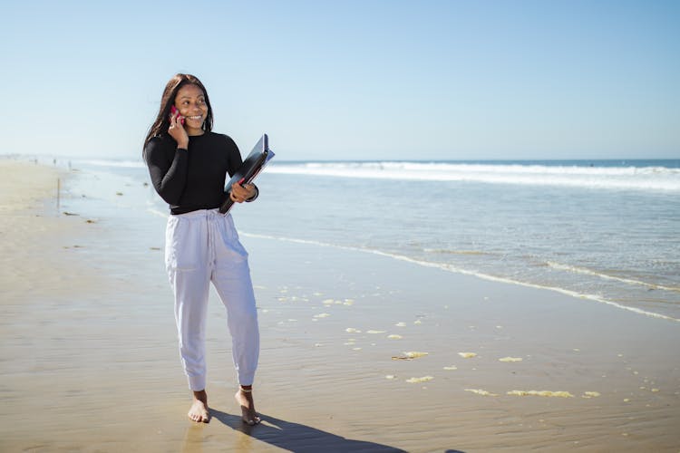 Woman Standing By The Beach Talking On The Phone