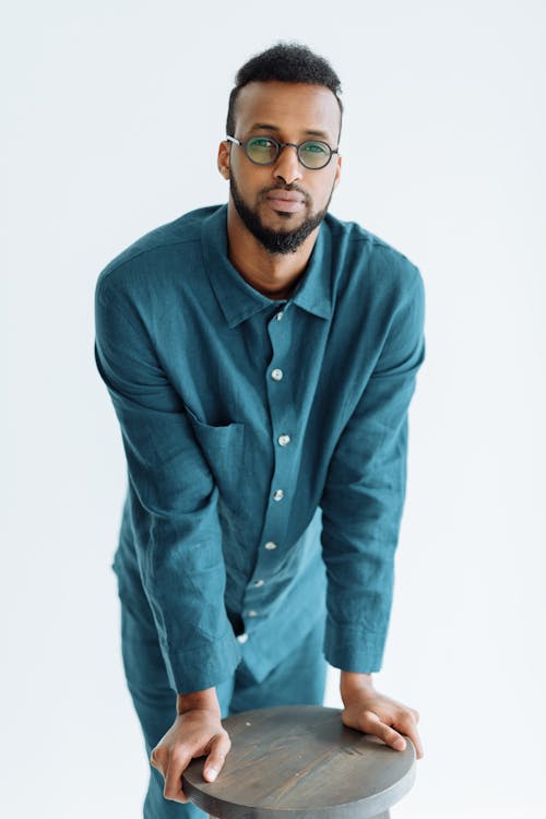 Man in Blue Long Sleeves Leaning on a Stool