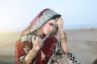 身着传统服装的优雅印度妇女在户外展示精致的珠宝和面料，摆出姿势