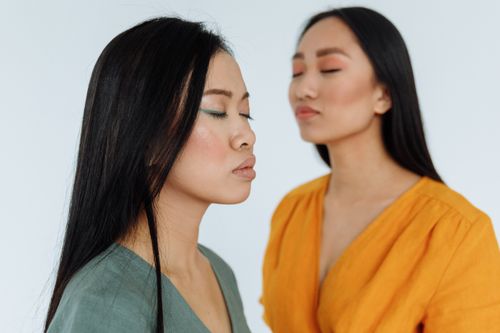 Free Two women with closed eyes and eye makeup showcasing a serene and stylized portrait indoors. Stock Photo