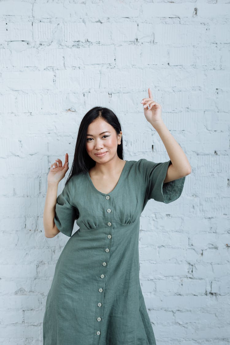 Woman In Button Down Dress Dancing While Smiling At The Camera