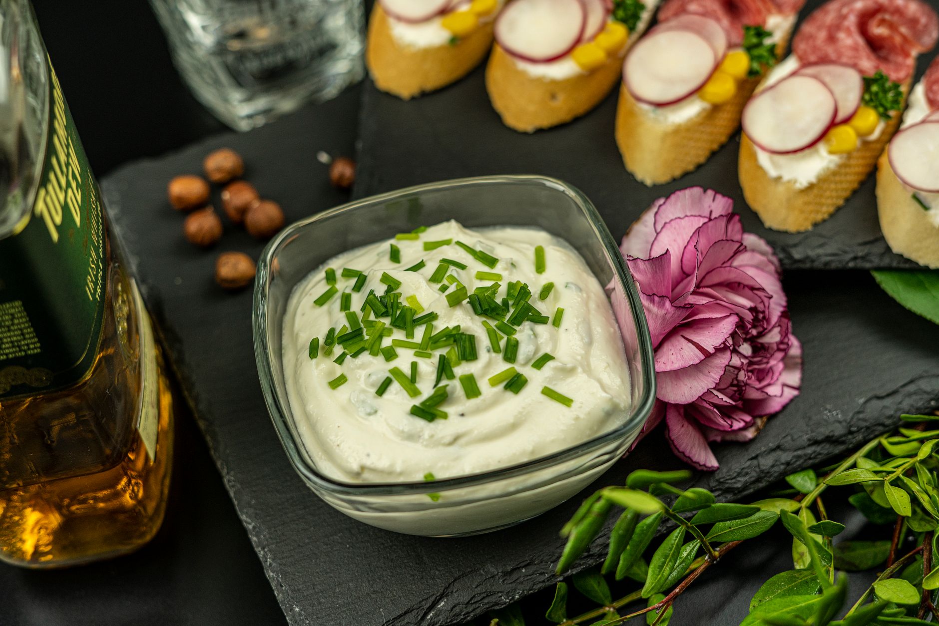 Creamy Blue Cheese Dressing That'll Win You Over Close-up of creamy dip in glass bowl with herbs, elegant appetizers and decorative flower.