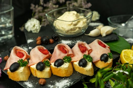Close-up of ham and olive canapés with creamy dressing, perfect for elegant gatherings.