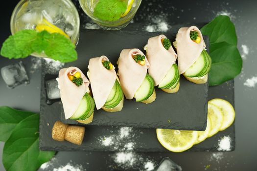 Elegant sandwich platter garnished with cucumber, lemon, and mint for a refreshing look.