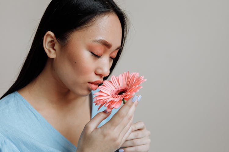 A Woman Smelling The Flower