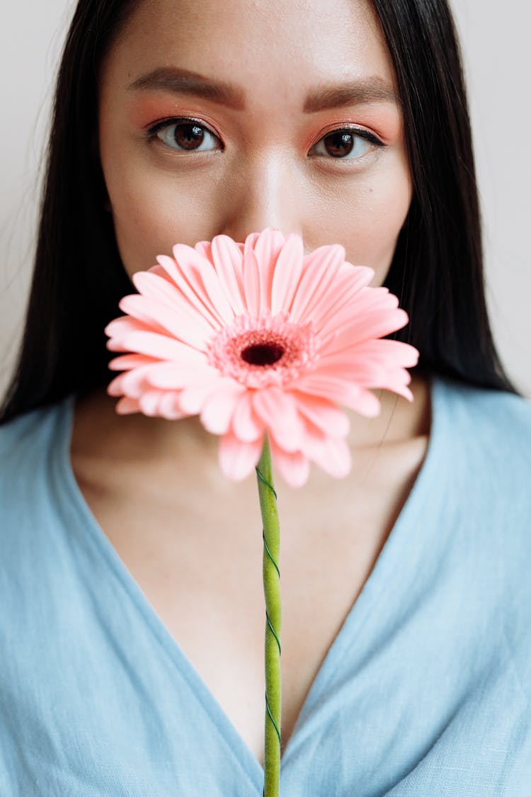 Woman Covering Her Mouth With A Flower