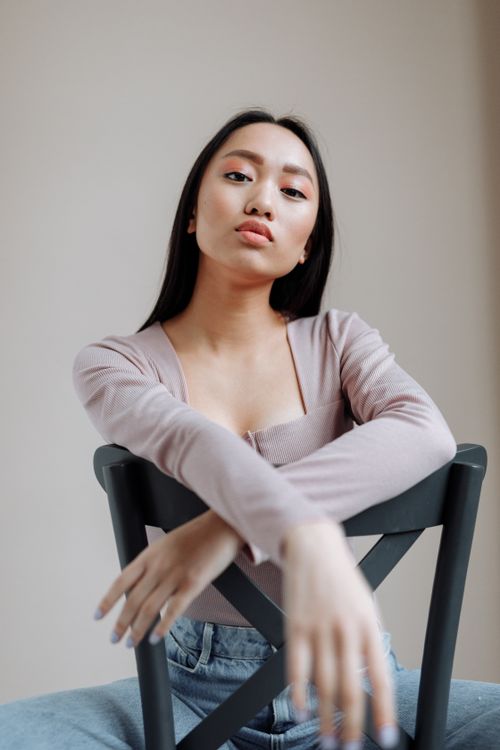 Free Portrait of a stylish woman with a confident pose indoors, exuding elegance and grace. Stock Photo