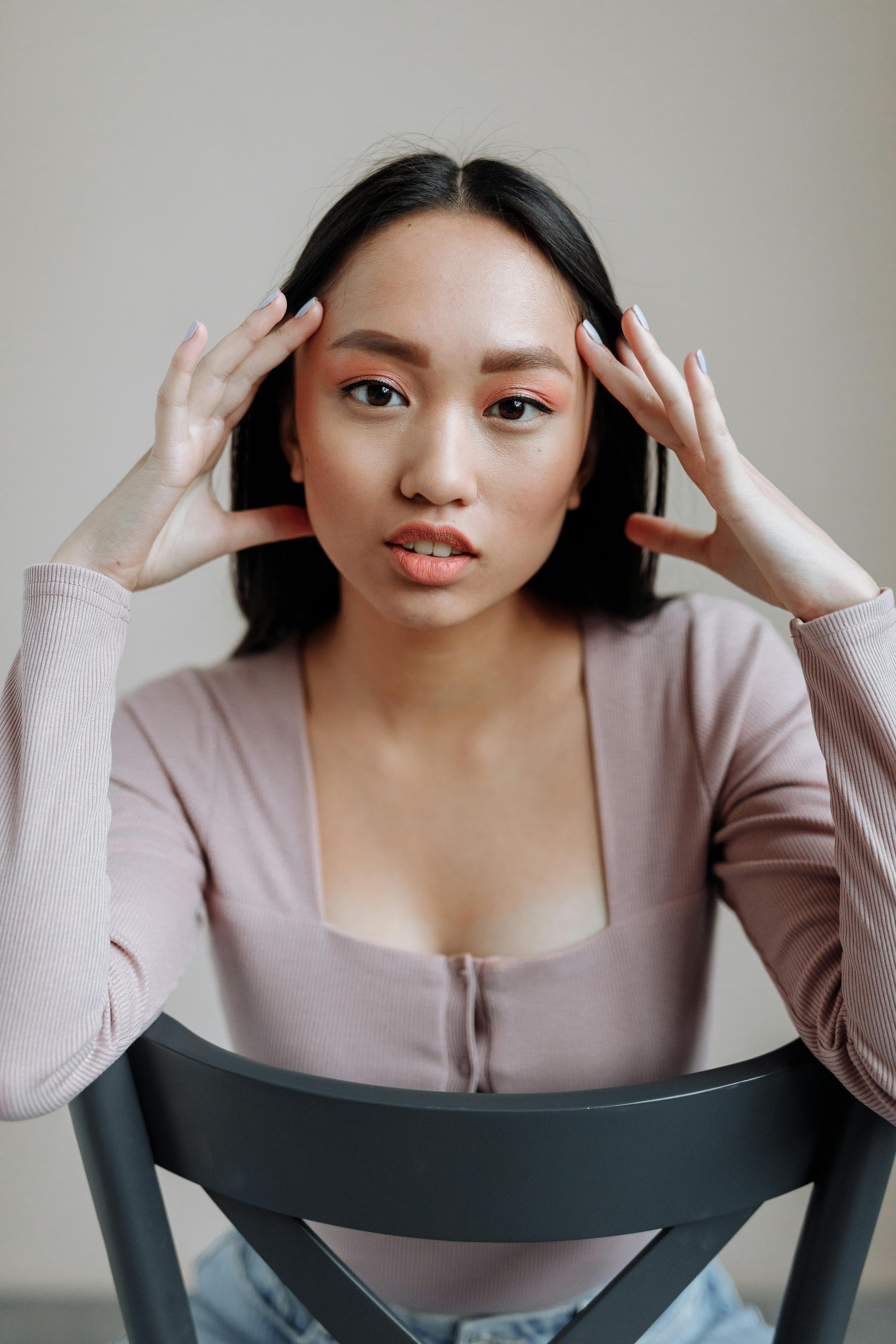 Vertical headshot of a serious woman in a modern setting, seated and looking intently.