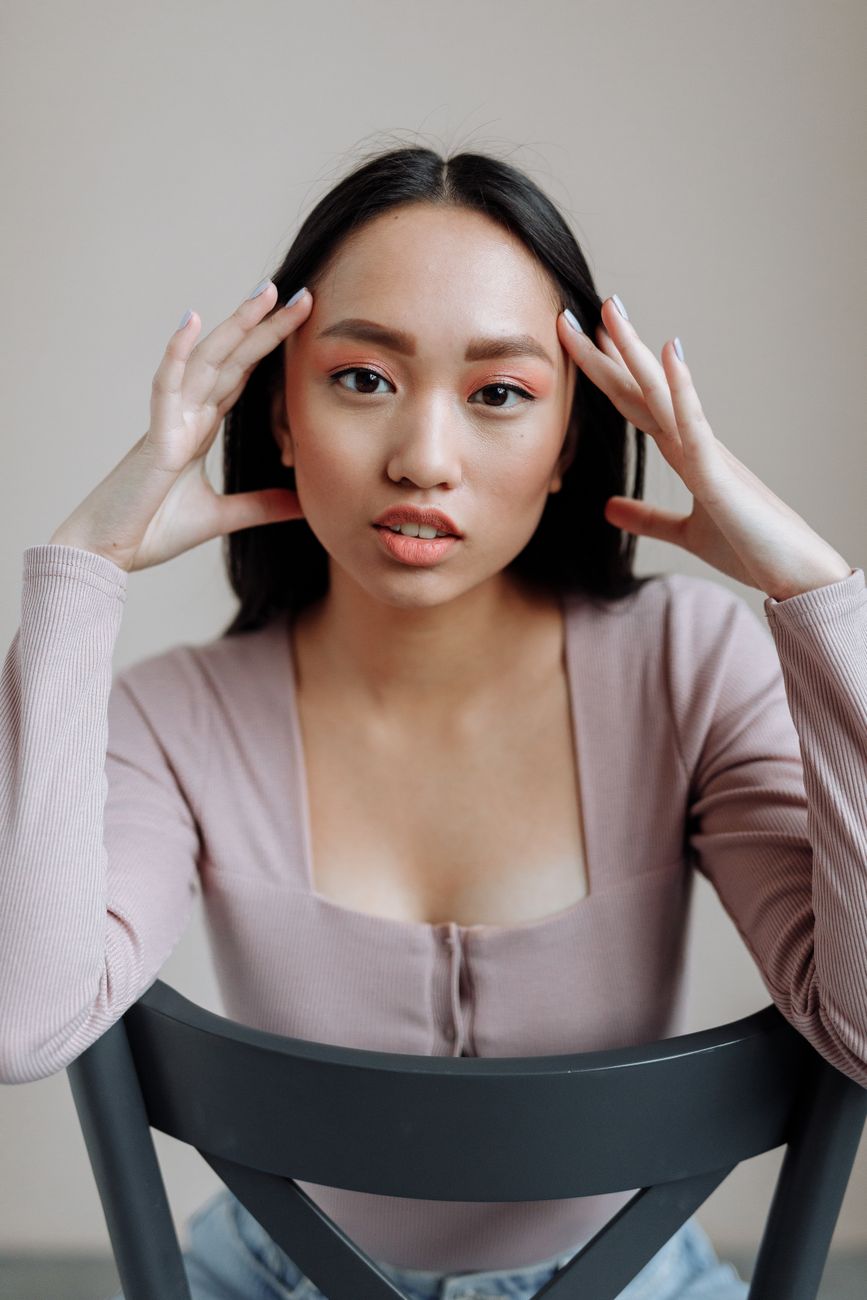 Vertical headshot of a serious woman in a modern setting, seated and looking intently.