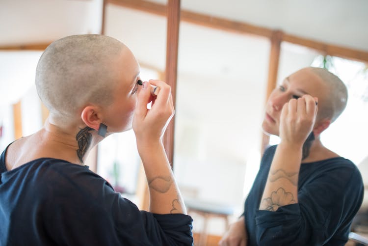 A Bald Woman Putting Makeup