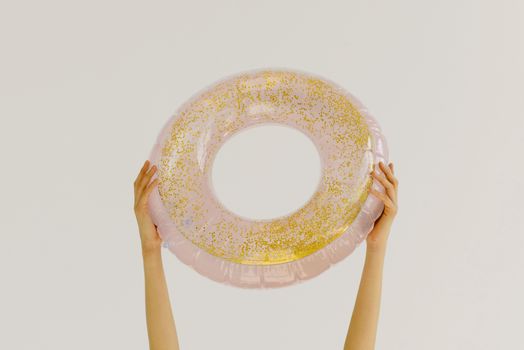 Person Holding Pink and Gold Floater