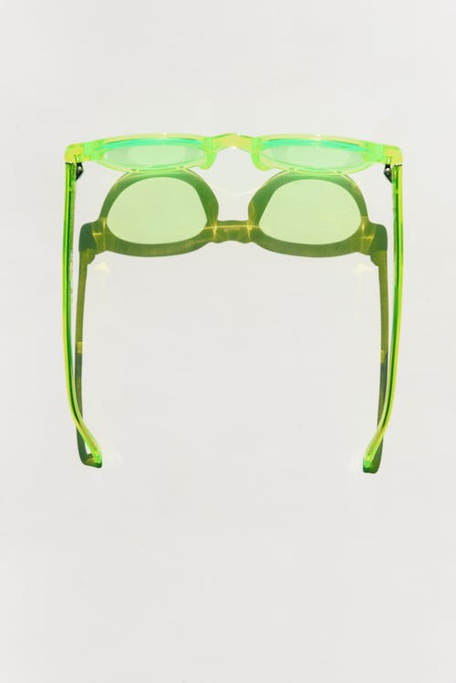 Green Framed Eyeglasses on White Surface