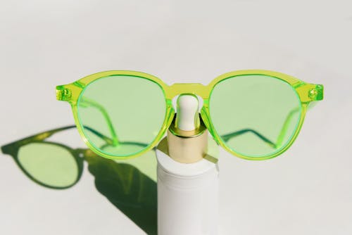 Green Framed Eyewear on Top of a Plastic Bottle