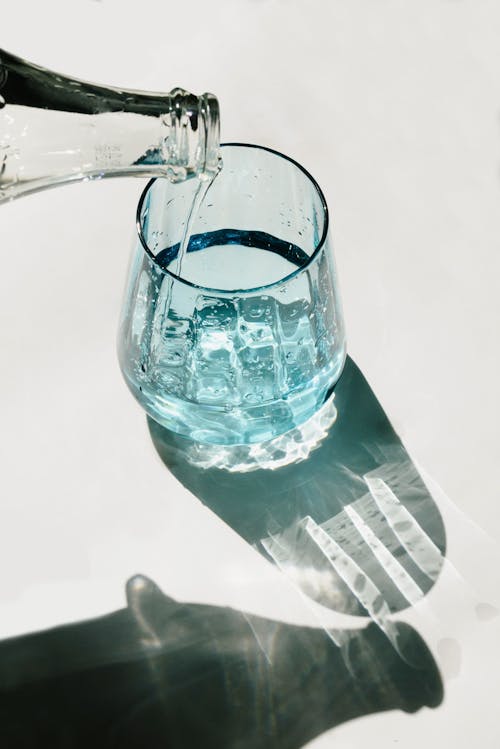 Free Person Pouring Water on Clear Drinking Glass Stock Photo