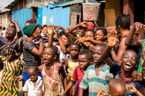 Free A diverse group of African children and adults celebrating at an outdoor community event. Stock Photo
