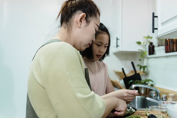 Mother And Daughter Cooking Together