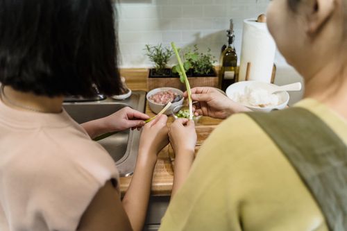 Free A mother and child preparing ingredients at a kitchen counter indoors, focusing on teamwork and learning. Stock Photo