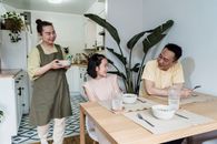 Woman in White Shirt Holding Green Plant