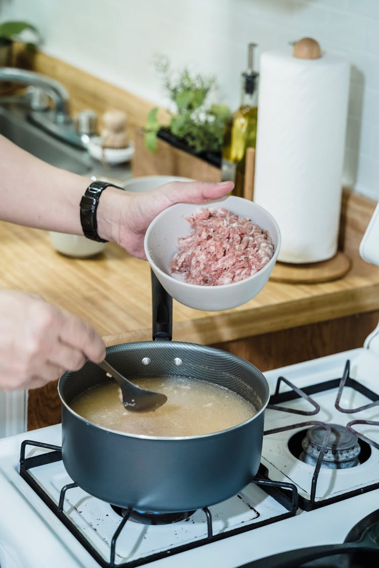 A Person Cooking A Soup Dish