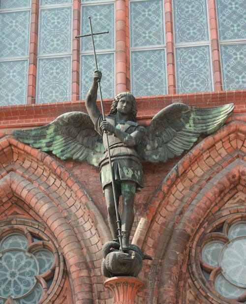 Black and Green Statue on the Brick Wall