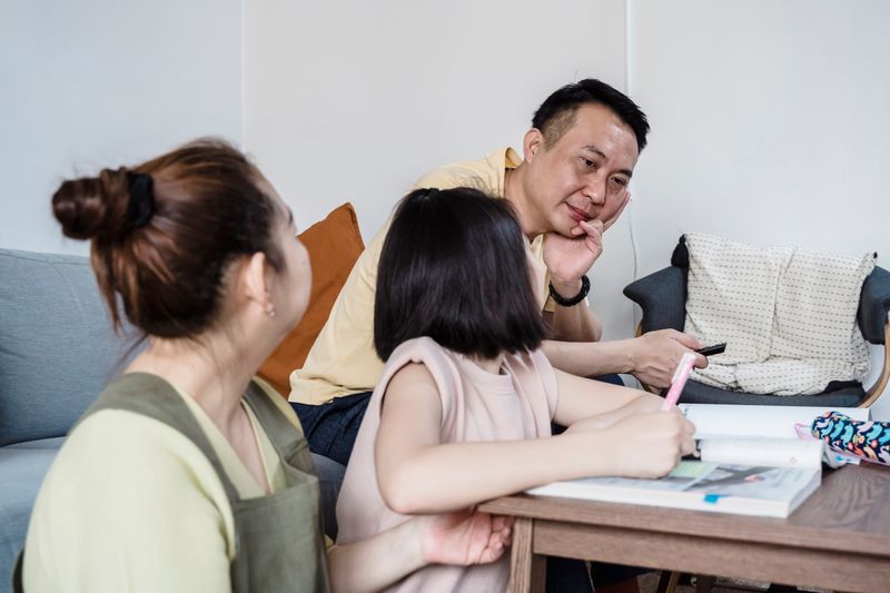 Parents helping a child with homework at home