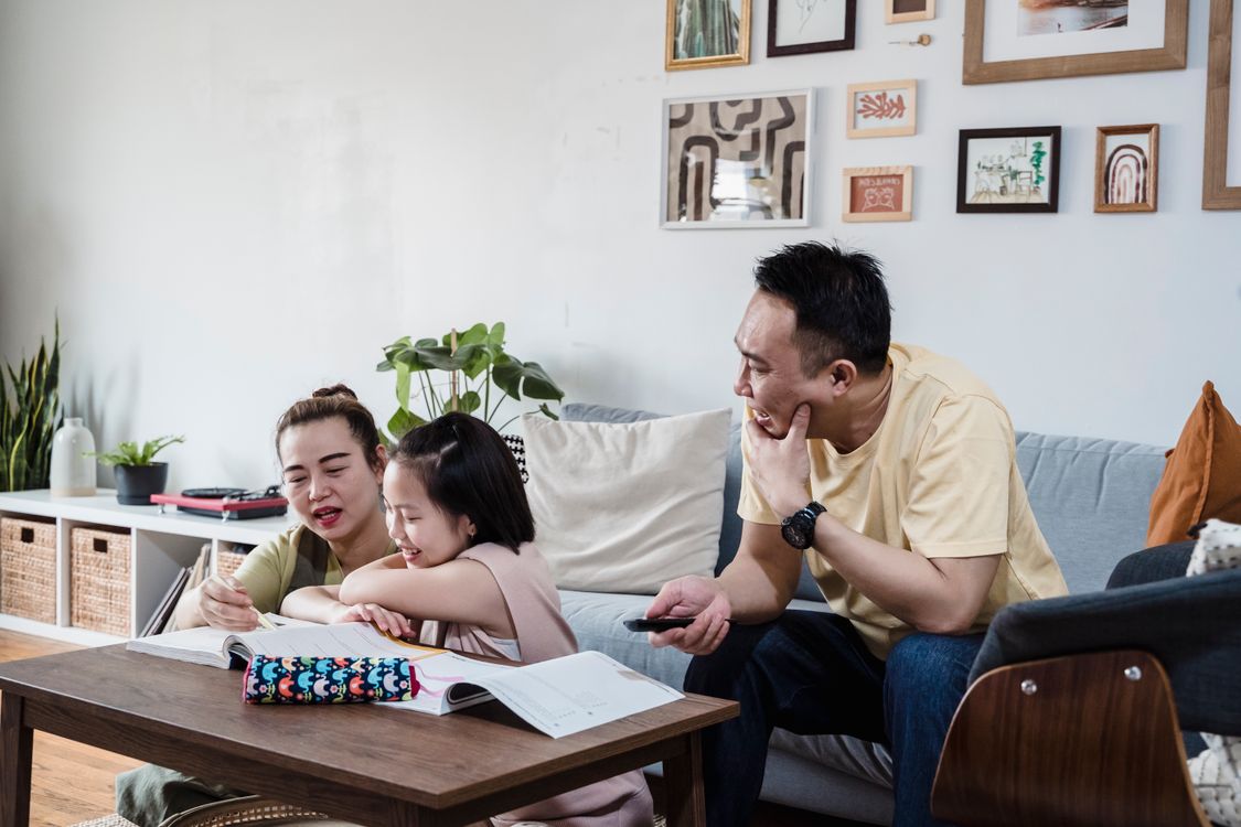 Parents Teaching their Child to Read in the Living Room · Free Stock Photo