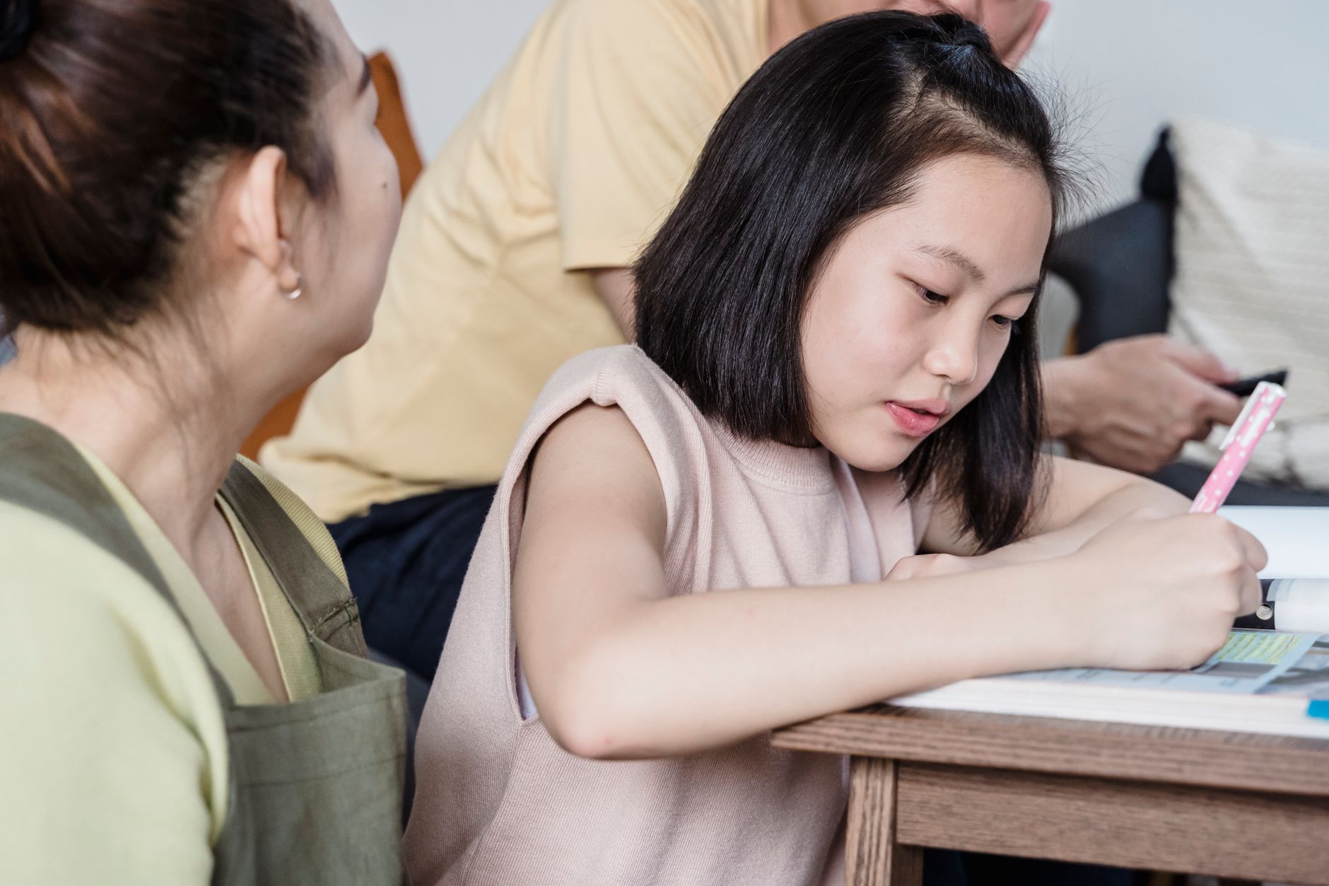 Parents and student sitting at a kitchen table reviewing household income documents