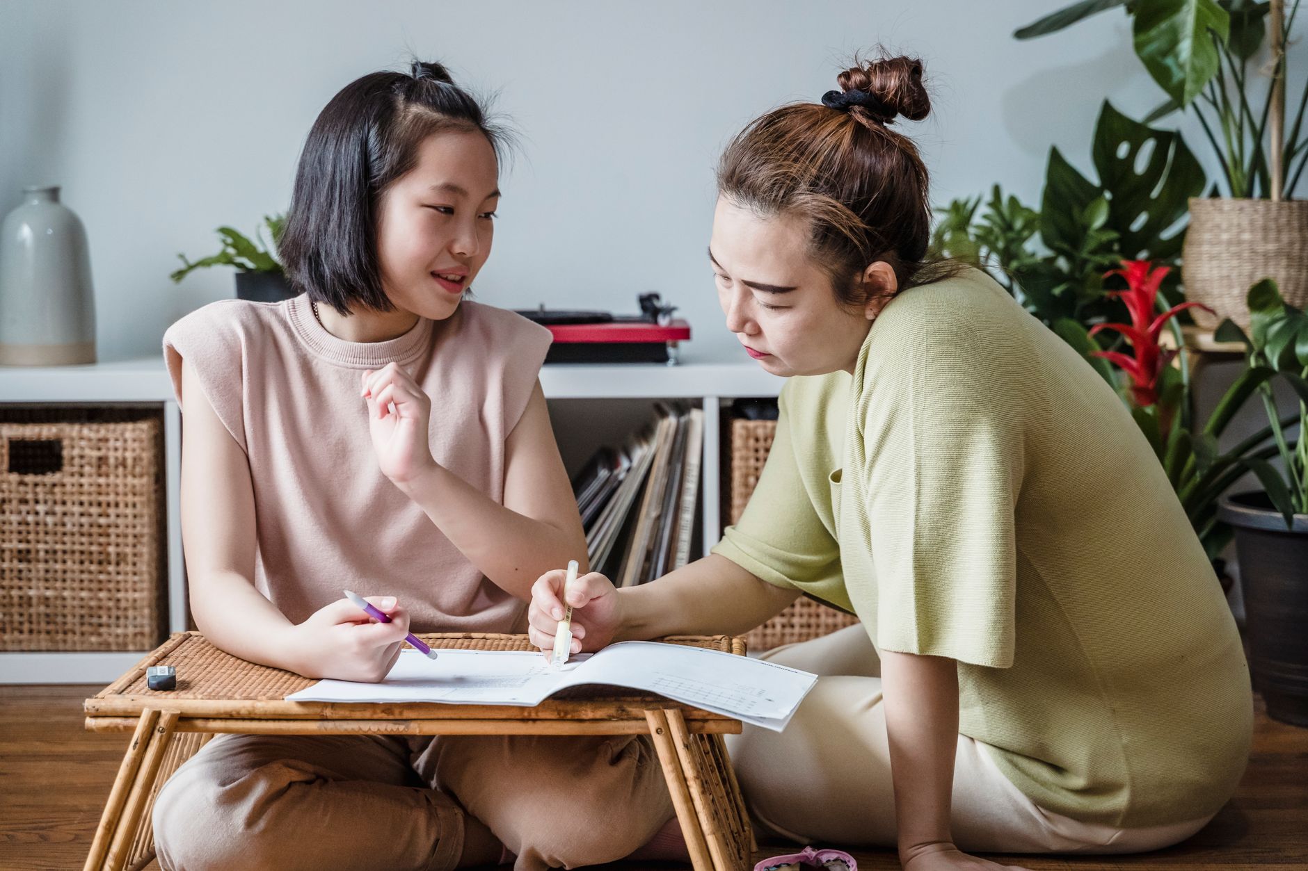 A mother and daughter studying indoors with books, fostering education and bonding.