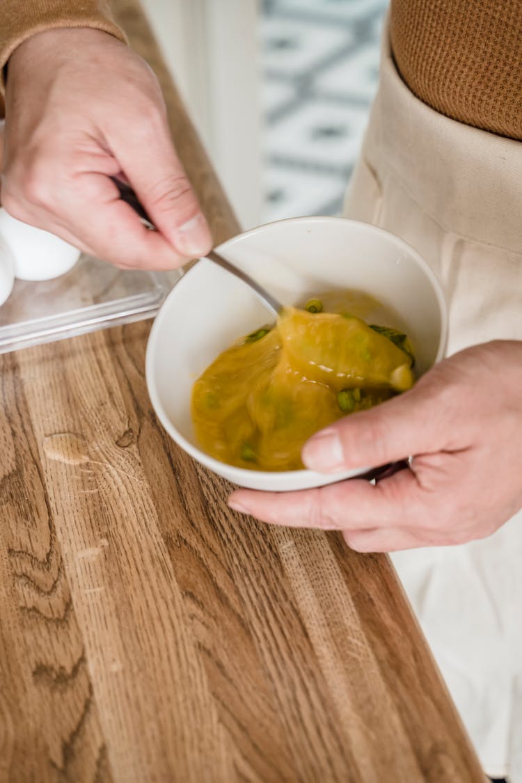 A Close-Up Shot Of A Person Beating An Egg