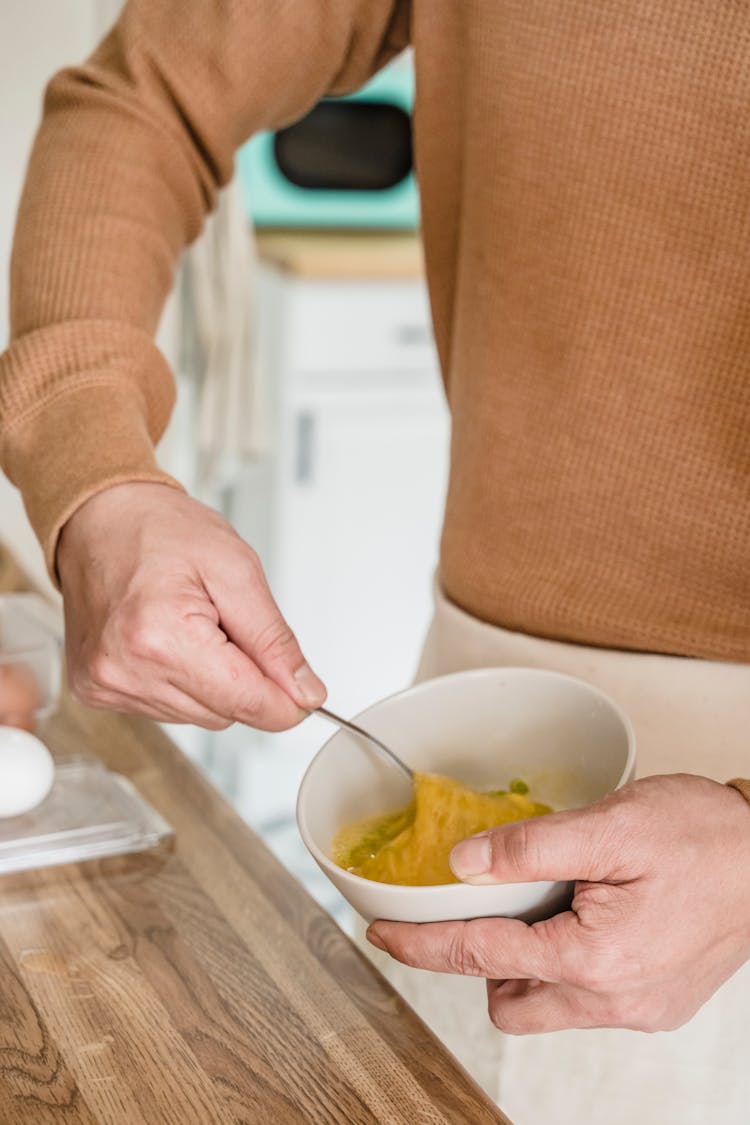 A Close-Up Shot Of A Person Beating An Egg