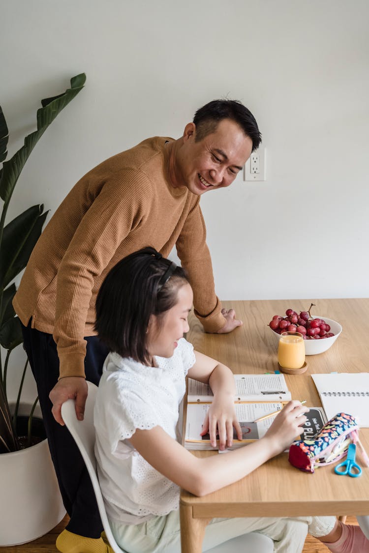 A Man Helping His Daughter With Her Homework