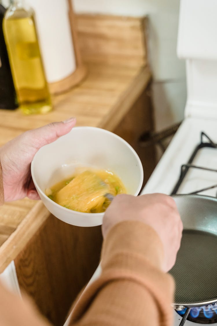 A Person Beating Eggs In A Bowl