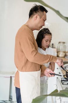 Father teaching daughter to cook in a cozy kitchen setting. Perfect for family and lifestyle themes.