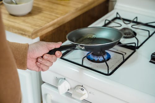 Free A Person Heating Oil in a Frying Pan Stock Photo