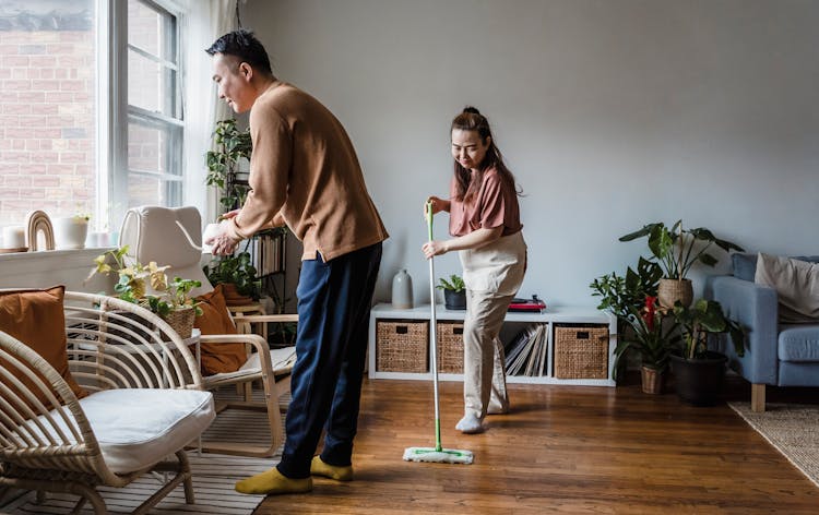 A Couple Cleaning The Living Room