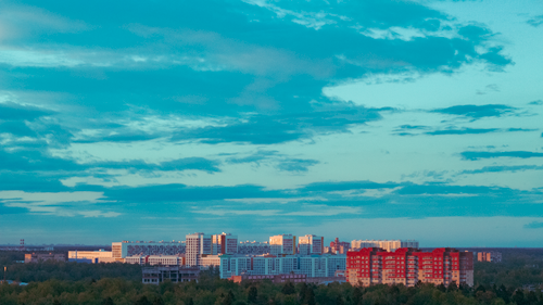 Free Aerial view of a vibrant cityscape with modern buildings under a bright blue sky. Stock Photo