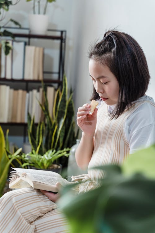 A Young Girl Sitting and Reading a Book