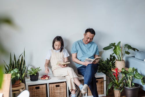 Father and Daughter Sitting Together and Reading Books