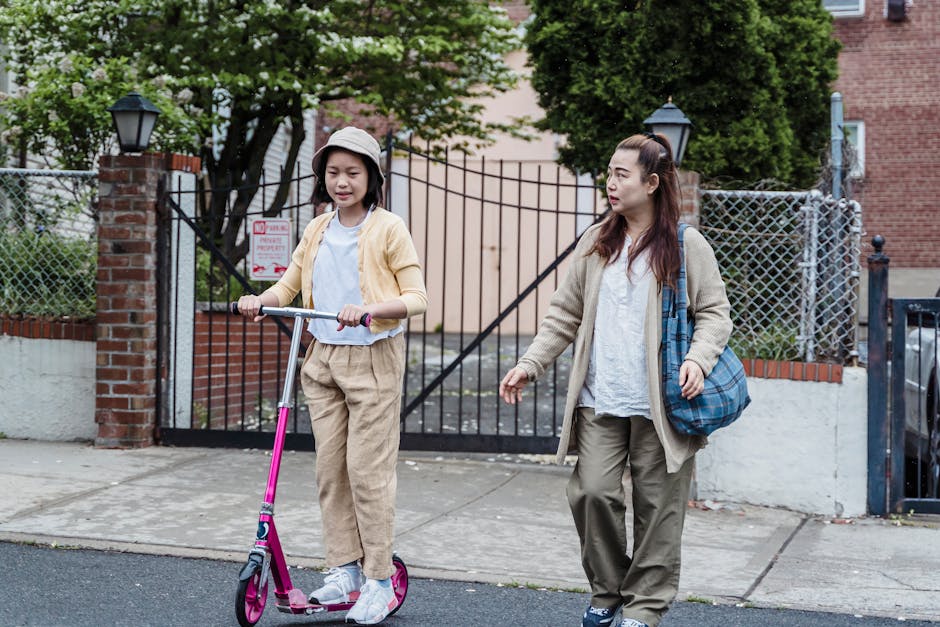 A parent and child walking safely on a tree-lined neighborhood sidewalk in spring. Photographed by Annushka Ahuja