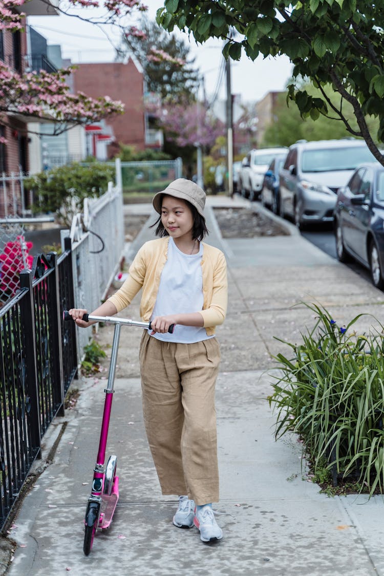 Girl Walking With A Push Scooter 